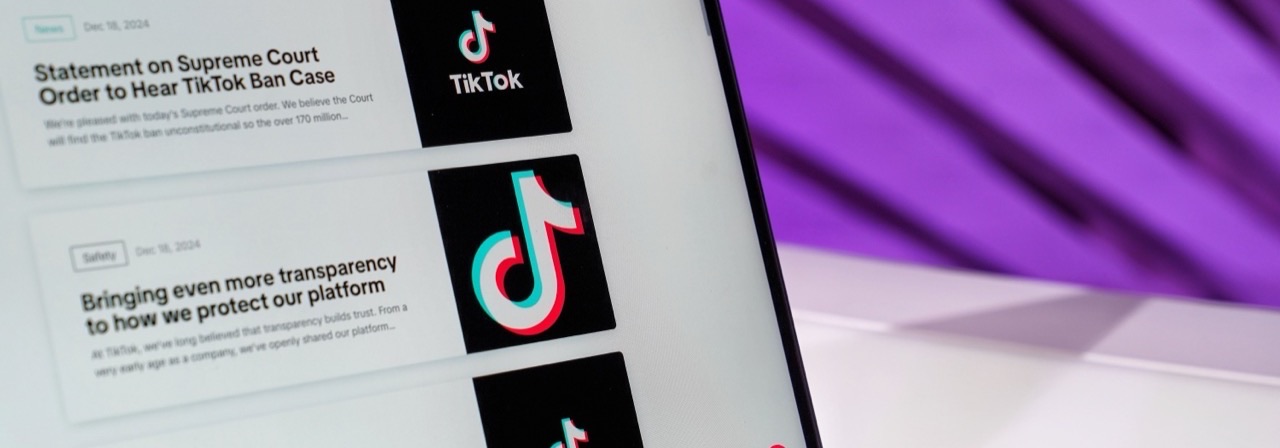 Laptop z newsroomem TikToka na fioletowym tle, temat prowizji afiliacyjnej TikTok Shop
