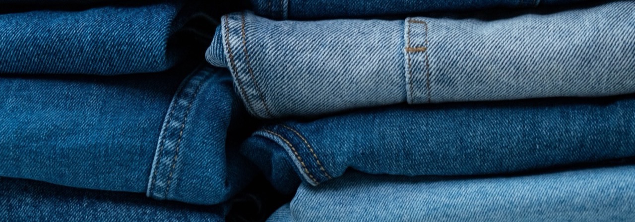 Stos jeansów w różnych odcieniach niebieskiego, nawiązanie do case Pacsun na TikTok Shop